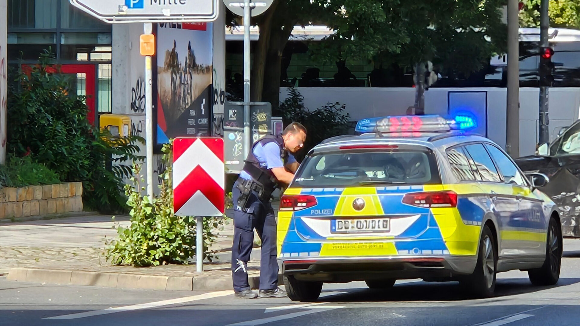 Polizist am Polizeiwagen Polizeiauto