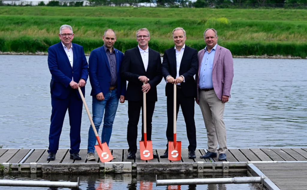 Sachsen-Energie-Vorstandschef Frank Brinkmann (2.v.r.) hat symbolisch den Spaten an den Dresdner Hochtief-Standortleiter Hagen Schroth (mitte) übergeben für den Bau des Flusswasserwerks. Hochtief ist Generalübernehmer für das gesamte Projekt, das 300 Millionen Euro kostet. Auf dem Steg: (v.l.n.r.) Heinrich Hünting (Abteilungsleiter Wirtschaft, Innovation und Mittelstand im Sächsischen Ministerium für Wirtschaft, Arbeit, Energie und Klimaschutz), Frank Bösenberg (Geschäftsführer Silicon Saxony), Hagen Schroth (Niederlassungsleiter Berlin-Brandenburg HOCHTIEF Infrastructure), Dr. Frank Brinkmann (Vorstandvorsitzender Sachsen-Energie), Dirk Hilbert (Oberbürgermeister der Stadt Dresden)